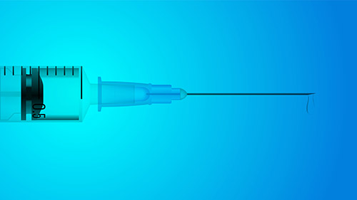A syringe in front of a blue background.