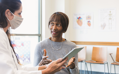 An older Black female patient speaks with a Latina clinician about bone loss and laboratory testing for bone turnover markers