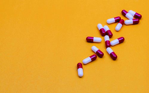 Red and white pills on a yellow background