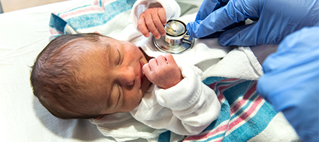 Doctor checking a newborn baby with a stethoscope